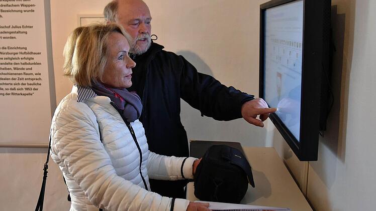 An dem interaktiven Touchpanel im Dokumentationszentrum Sankt Michaelskapelle des Videoteams der Pfarrei St. Kilian war auch der Historische Verein Haßberge beteiligt. Im Bild Wolfgang Jäger, Vorsitzender des Vereins, der der Stadtführerin Inge Appel die Funktionsweise erläutert.