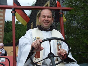 Traktorfahren im Habit und Messgewand? Bei Pater Stanislaus kein Problem: Fürs Pressefoto nahm er auf dem Oldtimer anlässlich der Oldtimer-Wallfahrt Platz. Jetzt verlässt der Geistliche das Kloster Kreuzberg. Foto: Archiv/Marion Eckert