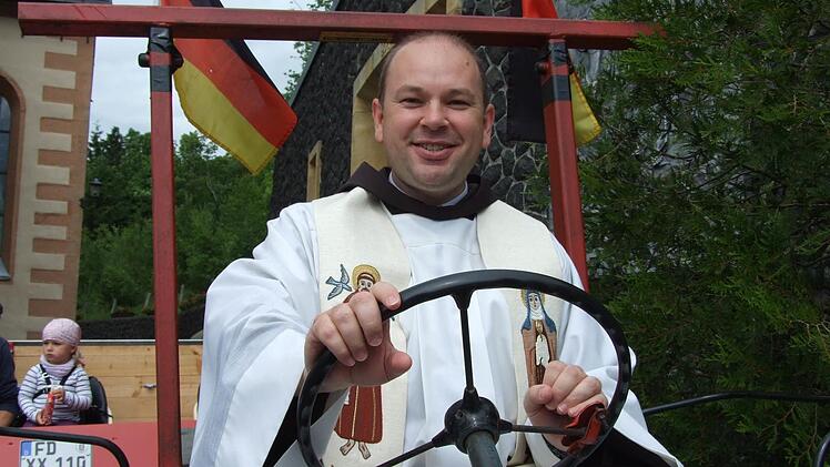 Traktorfahren im Habit und Messgewand? Bei Pater Stanislaus kein Problem: Fürs Pressefoto nahm er auf dem Oldtimer anlässlich der Oldtimer-Wallfahrt Platz. Jetzt verlässt der Geistliche das Kloster Kreuzberg. Foto: Archiv/Marion Eckert