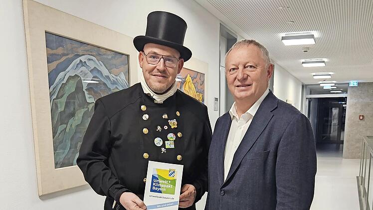 Landrat Thomas Bold überreichte die Urkunde für die Teilnahme am Umwelt- und Klimapakt Bayern an Kaminkehrermeister Felix Keßler.