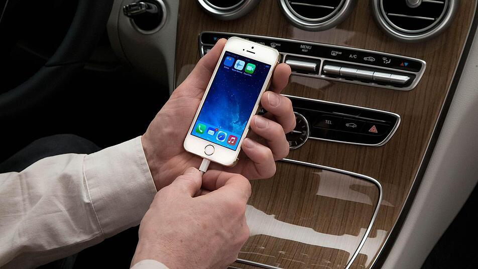 Ein Mann schließt in einem Wagen der neuen Mercedes-Benz C-Klasse ein iPhone an. Mit dem neuen System CarPlay, das iPhone und Navigationssystem des Autos verbindet, ist es möglich, Musik zu hören, zu navigieren, Nahcrichten zu empfangen und zu telefonieren. Foto:  Mercedes-Benz/dpa Ein Mann schließt in einem Wagen der neuen Mercedes-Benz C-Klasse ein iPhone an. Mit dem neuen System CarPlay, das iPhone und Navigationssystem des Autos verbindet, ist es möglich, Musik zu hören, zu navigieren, Nahcrichten zu empfangen und zu telefonieren. Foto:  Mercedes-Benz/dpa