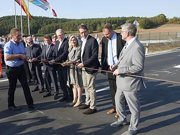 Zugreifen, bitte: Projektleiter Harald Schnappauf übernahm bei der Verkehrsfreigabe sogar die Verteilung der Scheren an Uwe Zeuschel, Friedrich Herdan, Hans Michelbach, Melanie Huml, Andreas Scheuer, Martin Mittag und Michael Busch  (von links) höchstpersönlich.Foto: Berthold Köhler
