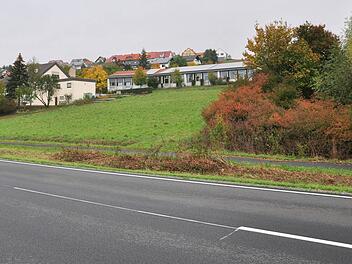 Das Baugebiet "Eichelberg III" in Gädheim soll von der B26 her erschlossen werden. Der neue Straßenabschnitt wird parallel zu B26 (vorne) verlaufen. Bedingt durch den Bau dieser Straßenanbindung wird der vorhandene Geh- und Radweg (dahinter im Bild) abschnittsweise überbaut. Foto: Ulrike Langer
