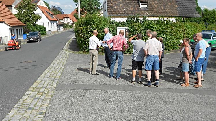 Die Anlieger der Brunnenleite, von denen einige zur Ortseinsicht gekommen waren, wünschen sich einen Verkehrsspiegel an der Ausfahrt zur Mühlstraße. Der Antrag wurde abgelehnt. Die Hecke (Hintergrund) wurde als Problem ausgemacht. Sie soll zurückgeschnitten werden. Das Foto mit Bürgermeister Helmut Dietz (2. von links), zeigt die Situation. Foto: Edgar Maier