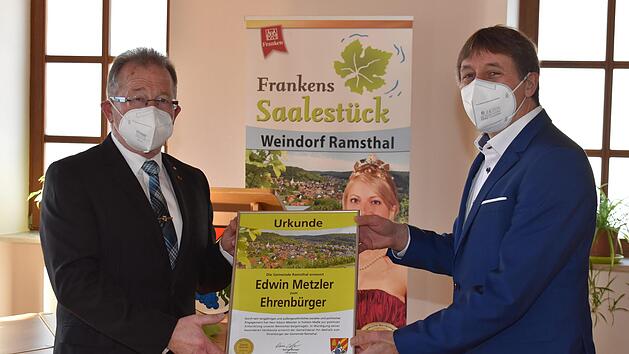 B&uuml;rgermeister Rainer Morper (rechts) &uuml;bergibt die Urkunde und Medaille an Edwin Metzler (links).  Foto: Andreas Lomb