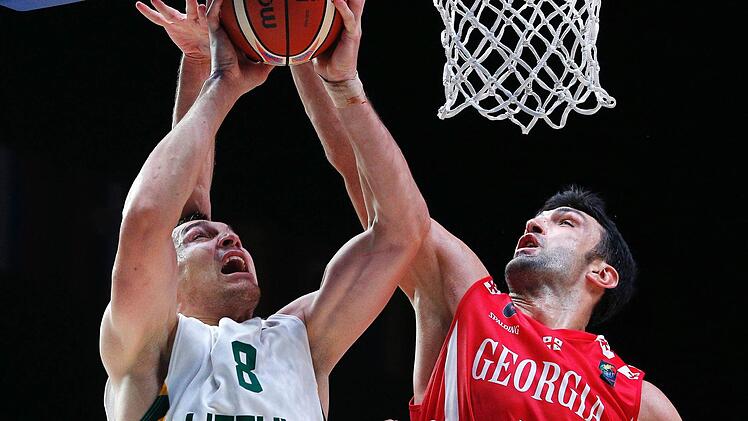 Litauens Jonas Maciulis (links) erzielt zwei seiner 32 Punkte gegen den NBA-Veteranen der Georgier, Zaza Pachulia. Foto: Voan Valat/dpa