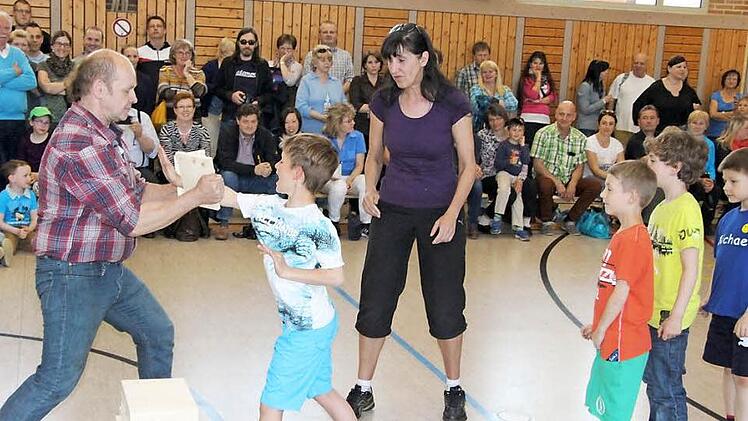 Wie man mit der Handkante ein Brett durchschlägt, zeigten Projektleiter Fred Busse und Heike Bittner den Kindern.  Fotos: Rainer Glissnik