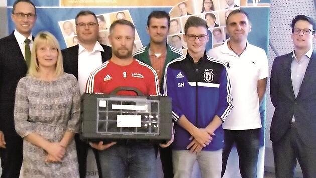 Volksbank-Vorsitzender Joachim Hausner (li.) und Julien Denis, Gesch&auml;ftsf&uuml;hrer von Sports Innovation Technologies (re.), &uuml;bergaben die Trainingskoffer an (v. li.) Silvia Wagner (TSV Kirchehrenbach), Christian Baier (JFG Aischtal), Sven Schulze (FC Burk), Stefan Pieger (FC Schlaifhausen), Sebastian Hutzler (FC Wichsenstein) und Wolfgang D&uuml;rrbeck (TSV Ebermannstadt).  Foto: privat