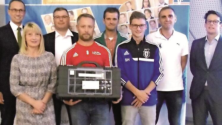 Volksbank-Vorsitzender Joachim Hausner (li.) und Julien Denis, Gesch&auml;ftsf&uuml;hrer von Sports Innovation Technologies (re.), &uuml;bergaben die Trainingskoffer an (v. li.) Silvia Wagner (TSV Kirchehrenbach), Christian Baier (JFG Aischtal), Sven Schulze (FC Burk), Stefan Pieger (FC Schlaifhausen), Sebastian Hutzler (FC Wichsenstein) und Wolfgang D&uuml;rrbeck (TSV Ebermannstadt).  Foto: privat