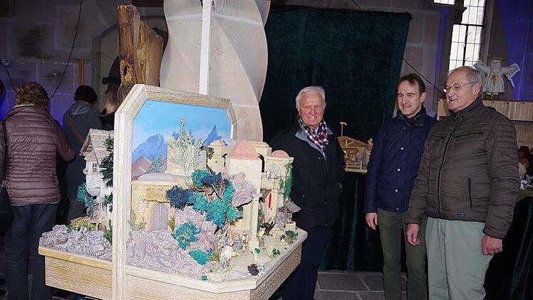 Die Hauptorganisatoren der Krippen-Ausstellung: Siegfried Schneider (links) und Werner M&uuml;ller (rechts), betrachten mit Kreisheimatpfleger Robert Wachter die Drehkrippe von Stefan Bauer aus Wallenfels. Foto: Heike Sch&uuml;lein