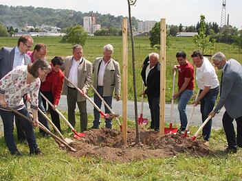 Andrea Künzl, Ralf Hartnack, Ingo Wolfgramm, Inge Aures, Henry Schramm, Ludwig Freiherr von Lerchenfeld, Michael Pfitzner, Khoschnaf Sulaimann, Ingo Lehmann und Benno Strehler (von links) pflanzten gestern symbolisch eine Linde in der Flutmulde. Foto: Anna-Lena Deuerling