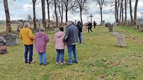 Besucher am Friedhof Reu&szlig;endorf. Am rechten Rand erkennt man Sch&auml;den, die Wildschweine angerichtet haben.