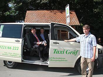 Auf den ersten Blick ist es ein Taxi, aber Fahrer Maximilian Vetter hält das Variobus-Schild hoch. Mit Unterstützung der Regierung von Oberfranken sollen auch etwas abgelegenere Orte mit öffentlichen Nahverkehrsmitteln erreichbar sein. Foto: Sonja Adam