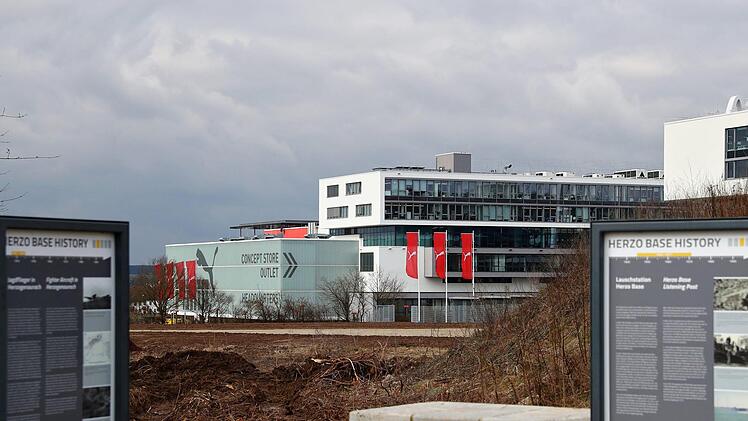 erzogenaurach: Die Firmenzentrale des Sportartikel-Herstellers Puma, im Vordergrund zwei Informationstafeln zum Gelände der ehemaligen US-Kaserne "Herzo Base".