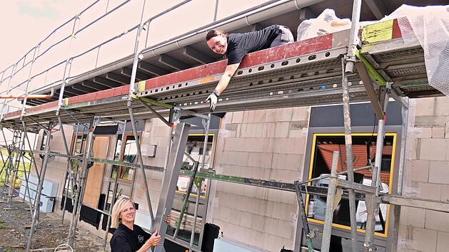 Frauenpower auf der Baustelle des Kindergartens "M&auml;useparadies": Andrea Lattner reicht Carina Hofmann auf dem Ger&uuml;st Material nach oben.