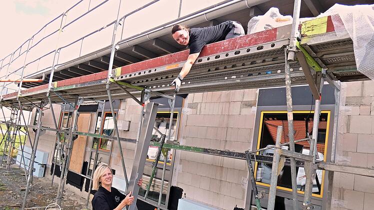 Frauenpower auf der Baustelle des Kindergartens "Mäuseparadies": Andrea Lattner reicht Carina Hofmann auf dem Gerüst Material nach oben.