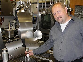 Jürgen Stahl misst die Fett-Temperaturen in einer Friteuse. Die grünen LEDs zeigen ihm, dass alles passt - nicht zu kalt, aber auch nicht zu heiß.  Foto: Ralf Kestel