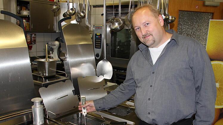 Jürgen Stahl misst die Fett-Temperaturen in einer Friteuse. Die grünen LEDs zeigen ihm, dass alles passt - nicht zu kalt, aber auch nicht zu heiß.  Foto: Ralf Kestel