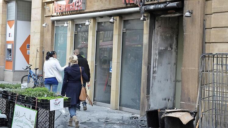 Auslöser des Laden-Brands: In den Gitterboxen (rechts) stand am frühen Dienstagmorgen Altpapier in Flammen. Die Polizei ermittelt nun wegen Brandstiftung.  Foto: Ronald Rinklef