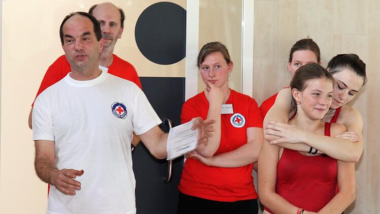 Verschiedene Rettungs- und Befreiungsgriffe f&uuml;hrten die Jugendlichen Julia H&uuml;lbig und Lana Schwarz vor, w&auml;hrend Zweiter Vorsitzender Andreas Einwag Erl&auml;uterungen gibt. Im Hintergrund (von links) stellvertretender Technischer Leiter Sven Faber, Wasserwacht-Kreisjugendleiterin Evamaria Gegner und Jugendleiterin Marina Gegner.Michael Will/BRK