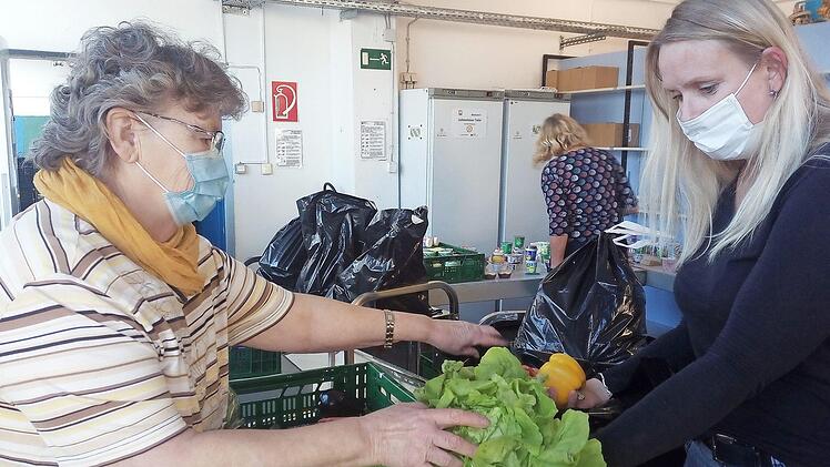 Brigitte Körner (links) und Stefanie Renner packen gemeinsam eine Tüte mit Lebensmitteln. Aus Hygienegründen können die Kunden aktuell nicht mehr in die Räume der Tafel. Sie bekommen die verpackten Rationen am Eingang ausgehändigt.  Foto: privat