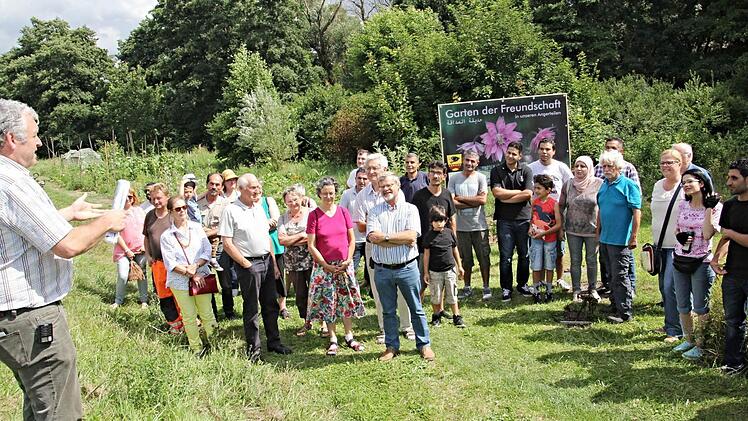 Bürgermeister Jürgen Hennemann (links) freute sich vor etlichen Ebernern und syrischen Flüchtlingen den "Garten der Freundschaft" eröffnen zu können. Im Hintergrund das Angerteil, welches von etwa zehn syrischen Familien bewirtschaftet wird. Foto: Helmut Will