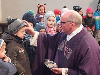 Stadtpfarrer Helmut Hetzel zeichnete auch den Kleinen des Don-Bosco-Kinderhauses ein Aschekreuz auf die Stirn. Fotos: Manfred Welker