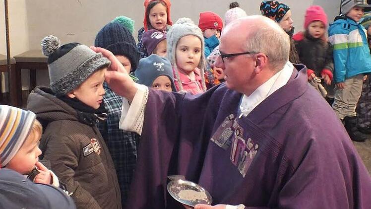 Stadtpfarrer Helmut Hetzel zeichnete auch den Kleinen des Don-Bosco-Kinderhauses ein Aschekreuz auf die Stirn. Fotos: Manfred Welker