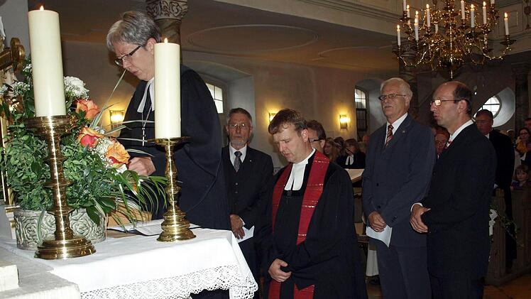 Dekanin Dorothea Richter (links) vollzieht die Einführung von Pfarrer Andreas Krauter (kniend) als neuer Pfarrer von Unterrodach, Zeyern und Wallenfels. Foto: Susanne Deuerling
