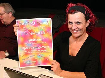 Susanne Gabler zeigt den Plakatentwurf, den die Anwesenden ausgewählt haben. Die Schrift soll jedoch dunkel werden und das Plakat größer. Foto: Evi Seeger