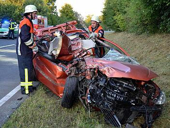 Zwei Einsatzkräfte am Unfallfahrzeug Foto: Peter Rauch