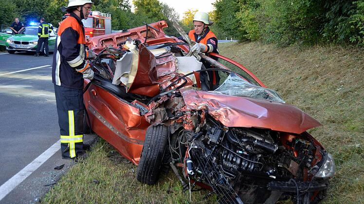 Zwei Einsatzkräfte am Unfallfahrzeug Foto: Peter Rauch