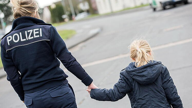 Eine Bundespolizisten k&uuml;mmert sich um ein Kind