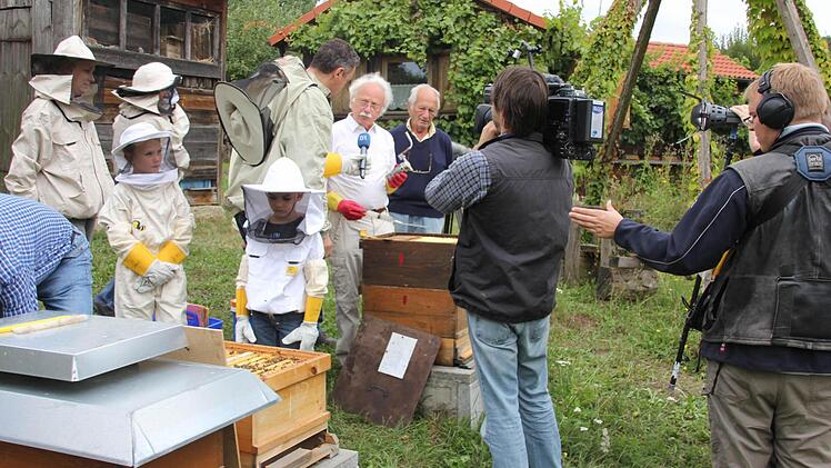 Ganz nah ran: BR- Reporter Markus Klingele interviewte Karl Schmitt über Möglichkeiten zur Eindämmung der Varroatose, mit im Bild auch zwei Enkel von Peter Kirchner sowie der 68-jährige Herbert Zeithaml aus Breitbrunn, allesamt "Neu-Imker". Fotos: Ralf Kestel