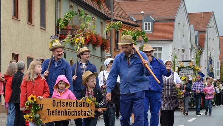 In blauer Arbeitskluft und mit geschmückten Rechen liefen die Tiefenhöchstadter Landwirte im Festzug mit. Foto: Andrea Spörlein