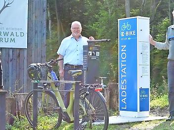 Constanze Stern, Geschäftsleiterin des Trägervereins Steigerwald-Zentrum, Manfred Schötz, Bürgermeister der Marktgemeinde Oberschwarzach, Andreas Leyrer, forstlicher Leiter Steigerwald-Zentrum, bei der E-Bike-Ladestation