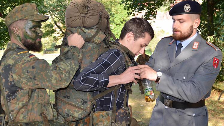 Wie fühlt es sich an, einen 15 Kilogramm schweren Rucksack mit sich herumzuschleppen? Das lässt Kadett Marc Hellbach (rechts) seinem Bruder Eric ausprobieren. Foto: Kathrin Kupka-Hahn