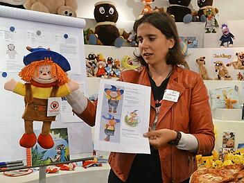 Josephine Dransfeld erklärt (unter Einhaltung von genügend Abstand) anhand einer Puppe für eine kleine Theatergruppe, wie ein Kundenwunsch für ein neues Produkt gut vorbereitet bei Heunec ankommen kann - was nicht immer der Fall ist. Foto: Rainer Lutz