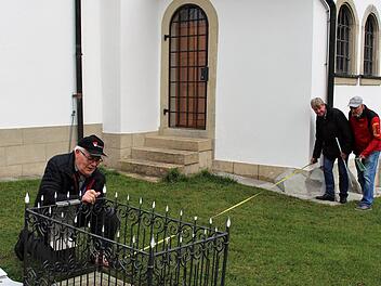 Von der Grabplatte zur Kirche hat sich der Abstand des Grabes seit Jahrzehnten nicht geändert. Georg Schockel (l.) hatte in seinem Ordner alle Maße genau aufgezeichnet. Manfred Welker und Rudolf Schwandner maßen nach. Foto: Evi Seeger