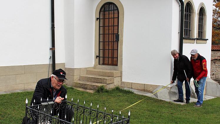 Von der Grabplatte zur Kirche hat sich der Abstand des Grabes seit Jahrzehnten nicht geändert. Georg Schockel (l.) hatte in seinem Ordner alle Maße genau aufgezeichnet. Manfred Welker und Rudolf Schwandner maßen nach. Foto: Evi Seeger