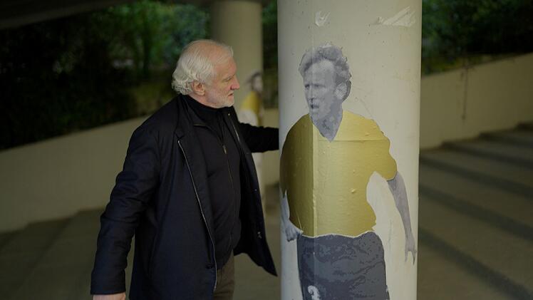Emotionale Szene neben einem Stadiongemälde. Rudi Völler entdeckt ein Konterfei seines Freundes Andreas Brehme. Sein Mitspieler in der Weltmeister-Elf von 1990 war nicht nur Mannschaftskollege, sondern auch Völlers bester Freund. Im Februar 2024 ist Brehme - wie Völler 1960 geboren - überraschend verstorben.