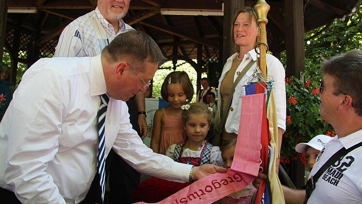 Oberbürgermeister Henry Schramm heftet das neue Fahnenband an.