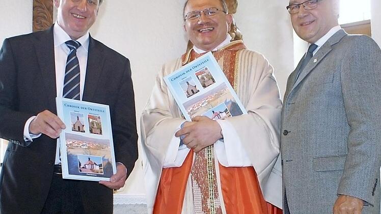 Bürgermeister Bruno Kellner, Pfarrer Reinhold Braun und Autor Manfred Jungkunz (von links) freuen sich über die neue Chronik. Foto: nr
