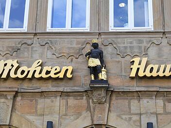 Die Schlange um den Arm wie beim Äskulapstab, dem Symbol des ärztlichen und pharmazeutischen Standes, und neben sich einen Mörser: Die Hausfigur über dem Eingang des Mohrenhauses, der ehemaligen Mohrenapotheke, trägt die Insignien der Heilkunde.  Foto: Ronald Rinklef
