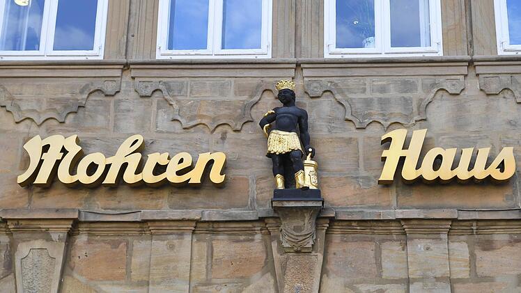 Die Schlange um den Arm wie beim Äskulapstab, dem Symbol des ärztlichen und pharmazeutischen Standes, und neben sich einen Mörser: Die Hausfigur über dem Eingang des Mohrenhauses, der ehemaligen Mohrenapotheke, trägt die Insignien der Heilkunde.  Foto: Ronald Rinklef