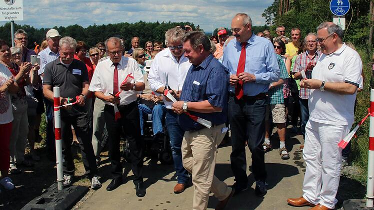 Das obligatorische Band zur Freigabe des Radweges zwischen Rannungen und Pfändhausen zerschnitten (von links) der stellvertretende Schweinfurter Landrat Peter   Seifert, sein Bad Kissinger Kollege Emil Müller, der Dittelbrunner   Bürgermeister Willi Warmuth, Staatssekretär Gerhard Eck, der Rannunger   Bürgermeister Fridolin Zehner und der Schweinfurter Bezirksrat Stefan Funk . Dieter Britz