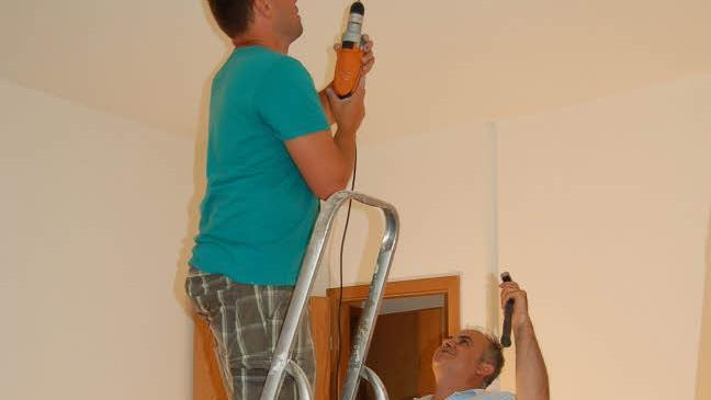 André Miller (auf der Leiter) und Herish Rasol beim Herrichten von neuen Wohnungen in Coburg für Flüchtlinge Foto: Helke Renner