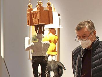 Ein Besucher der Ausstellung betrachtet eine der Skulpturen von Lothar Seruset.
