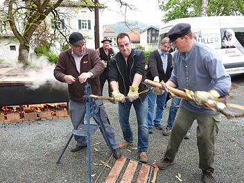 Viel Spaß hatten die Flößer beim kräftezehrenden Wiedendrehen. Links im Bild der mit Holz befeuerte Edelstahltrog, in dem die Haselnussruten und Fichtenstämmchen im kochenden Wasser "gebäht" wurden.  Foto: Gerd Fleischmann