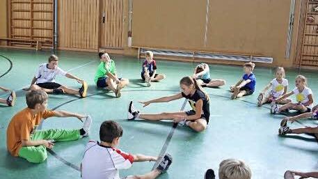 Mit Dehnübungen wärmte Co-Trainerin Maya Mützel (Mitte) die Kids auf.   Foto: Geiger